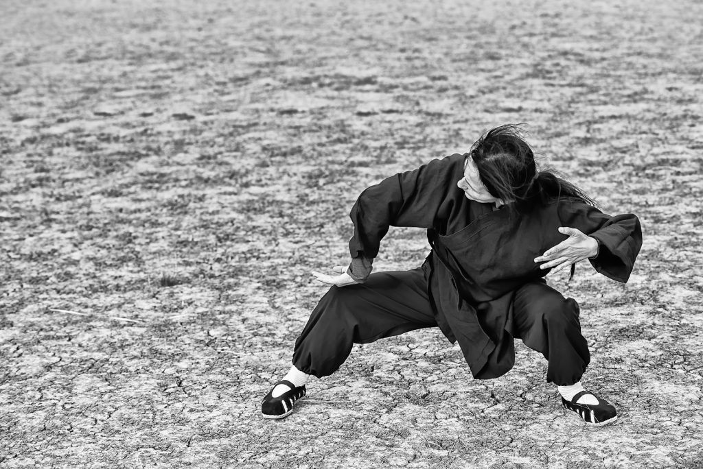 Jeune homme faisant du Tai chi en extérieur sur la plage de Dinard